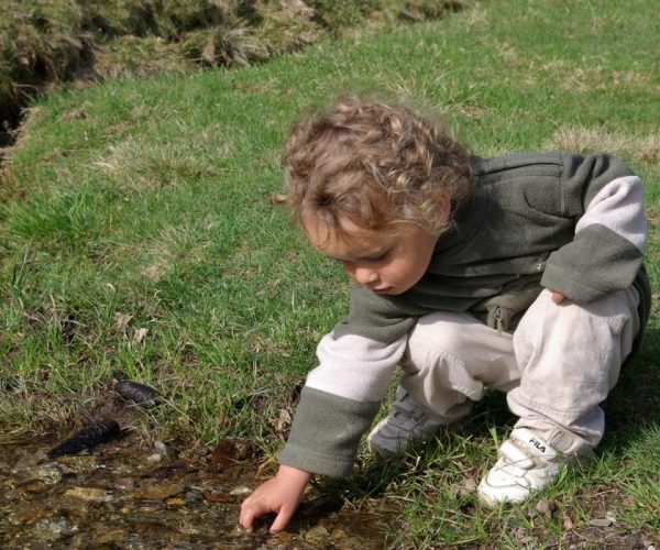 Enfant jouant dans le torrent au parc de Merlet