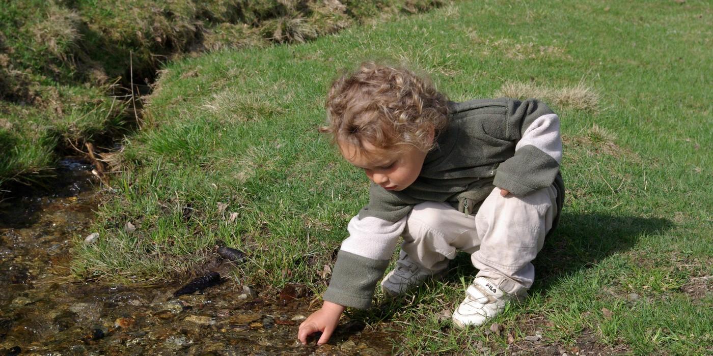 Enfant jouant dans le torrent au parc de Merlet